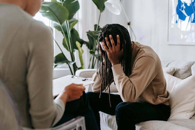 Seated woman holding head in pain